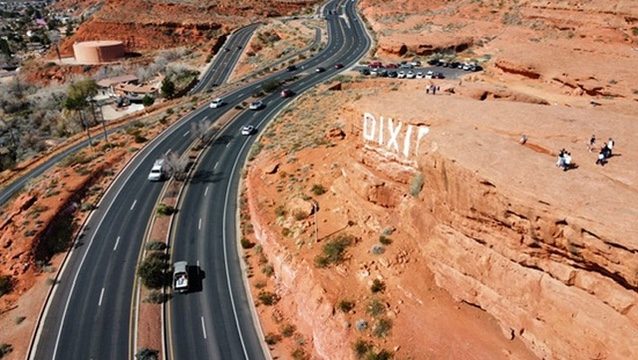Aerial view of a highway beside red rock cliffs in southern Utah